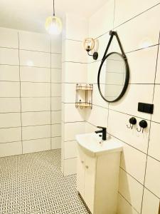 La salle de bains est pourvue d'un lavabo et d'un miroir. dans l'établissement GÓRSKA CISZA - Apartamenty, à Stronie Śląskie