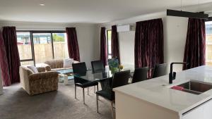 cocina y sala de estar con mesa y sillas en Newly built house, en Lower Hutt