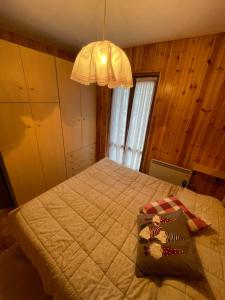 - une chambre avec un lit et un lustre dans l'établissement Casa Cedrone, à Aprica
