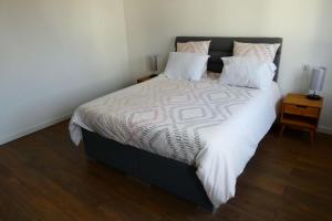 1 dormitorio con 1 cama grande con sábanas y almohadas blancas en Vaste appartement cosy avec parking gratuit et espace de travail, en Illkirch-Graffenstaden