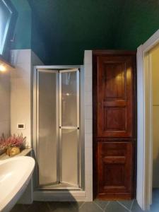 a bathroom with a glass shower and a wooden cabinet at Appartamento sotto la Mole Antonelliana in Turin
