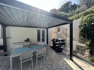 a patio with a table and a grill at Fantastic villa in the bay of Cannes, 5 minutes from the beach - with private pool in Mandelieu-la-Napoule