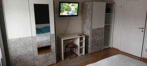 Habitación con TV en la pared y cama en ApartmentMR, en Maribor