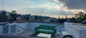 a green chair sitting on top of a roof at The house in Jerusalem in Jerusalem