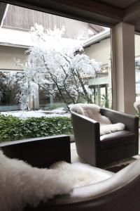 ein Wohnzimmer mit einem Stuhl und einem Fenster in der Unterkunft Palace Hotel Wellness & Beauty in Bormio