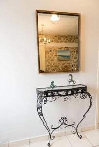 a mirror on the wall above a bench in a bathroom at Το Πέτρινο in Aitolikón