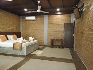 um quarto com uma cama e uma parede de tijolos em Kaveri Resort Sigiriya em Sigiriya