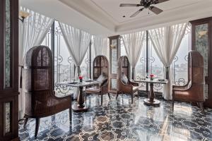ハノイにあるLa Mejor Hotel & Sky Barのダイニングルーム(椅子、テーブル、窓付)