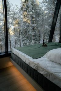 a bed in a room with a large window at Salla Wilderness Lodges in Salla