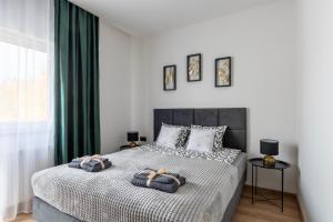 a bedroom with a bed with two pillows on it at Apartamenty RIO Skarbimierz-Osiedle in Skarbimierz Osiedle