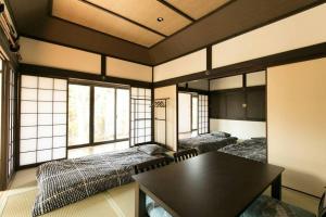 a room with three beds and a table in it at Traditional/modern Kyoto Paradise in quiet area! in Iwakura