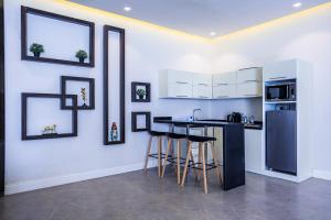 a kitchen with a counter with stools and a refrigerator at Arjan Park Resorts in Riyadh