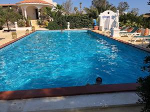 a man is standing in a large swimming pool at Oasi Di Casablanca in Lampedusa
