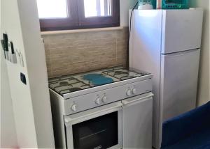 una cucina con piano cottura e frigorifero di Sea and Blue Sky 2 a Calimera
