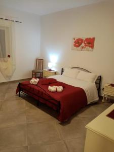 a bedroom with a bed with a red blanket at La Casa di Antonella in Agrigento