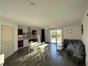 a kitchen and living room with a table and a couch at maison village vacances demeures du Ventoux in Aubignan