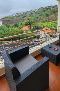 a balcony with a couch and a table with a view at Formosa Sunset in Funchal