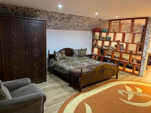 a bedroom with a bed and a couch and a chair at Mill House in Cluj-Napoca +10 photos