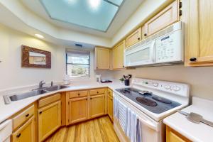 a kitchen with white appliances and wooden cabinets at Canyon View #19201 in Tucson