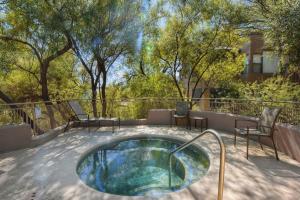 einen Whirlpool auf einer Terrasse mit Stühlen und Bäumen in der Unterkunft Canyon View #19201 in Tucson