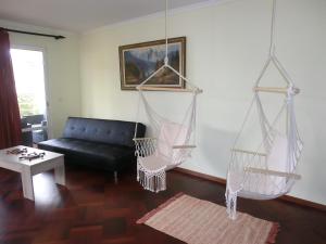 een woonkamer met een zwarte bank en hangmatten bij Formosa Sunset in Funchal