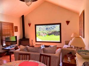 ein Wohnzimmer mit einem Sofa und einem Fenster in der Unterkunft Casa Rural CaChispita in Teror