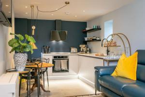 ein Wohnzimmer mit einer blauen Couch und einer Küche in der Unterkunft Luxurious one bedroom house in Embsay + 20 Fotos