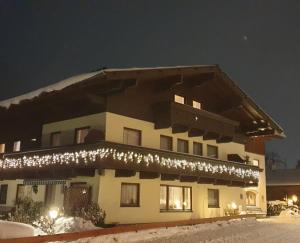 a building with christmas lights on it in the snow at Pension und Appartement Weinschreiber in Rauris
