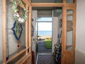 een deur naar een hal met uitzicht op de oceaan bij Glasfryn in Cemaes Bay