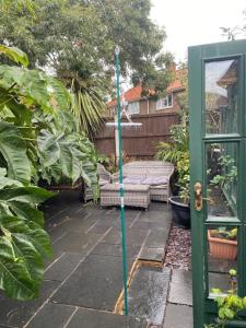 a garden with a green pole on a patio at Willow Guest House in Norwich