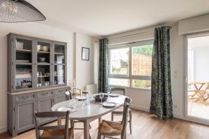 a dining room with a table and chairs and a window at Le Jardin d'Ulysse - 2 chambres avec parking in Nantes