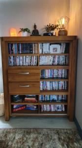 a wooden book shelf filled with dvds at 'Ar Y Tonnau' Y Felinheli Waterside Apartment in Y Felinheli
