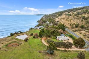 an aerial view of a house on a hill next to the ocean at Hamptons on the Bay in Swansea