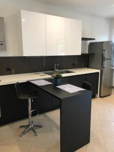 a kitchen with a black counter and white cabinets at CORTE COLOMBARON vicino a Gardaland in Ronchi