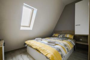 a bedroom with a bed with yellow sheets and a window at Apartman Maslacak in Divčibare