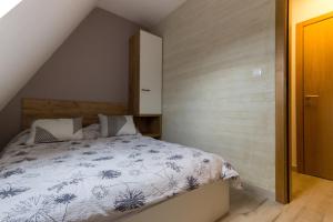 a bedroom with a bed with a blue and white comforter at Apartman Maslacak in Divčibare