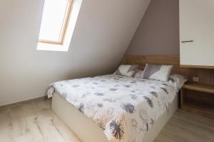 a small bedroom with a bed in a attic at Apartman Maslacak in Divčibare