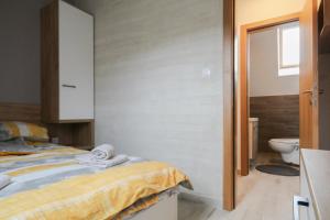 a bedroom with a bed and a toilet in it at Apartman Maslacak in Divčibare