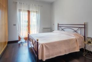 1 dormitorio con 1 cama en una habitación con ventana en Caronni 52 Villa Country & Business Ostia Antica, en Ostia Antica