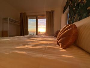 - une chambre avec un lit et une vue sur le coucher du soleil dans l'établissement Villa Lattea, à Aci Trezza