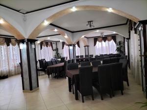 a dining room with black tables and chairs at Pensiune Stirbu in Borsa