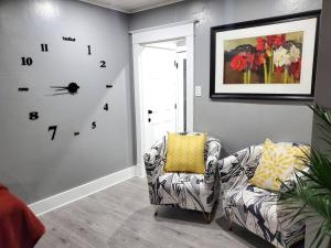 a room with a chair and a clock on the wall at PRIVATE & COMFORTABLE Full house near Royal Alexandra Hospital Stadium Downtown & Mall Access in Edmonton