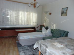 sala de estar con sofá, cama y piano en Ferienwohnung Wawrok en Pirna