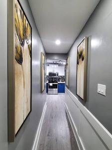 a hallway with paintings on the walls of a kitchen at PRIVATE & COMFORTABLE Full house near Royal Alexandra Hospital Stadium Downtown & Mall Access in Edmonton