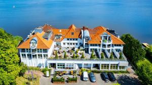 - une vue aérienne sur un grand bâtiment blanc avec un toit orange dans l'établissement Seehotel Fährhaus, à Bad Zwischenahn