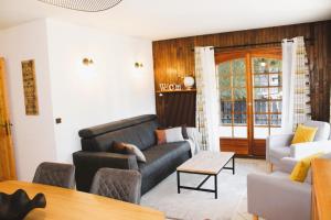 una sala de estar con un sofá y una mesa en Appartement Helios, en Les Gets