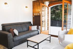uma sala de estar com um sofá e uma mesa de centro em Appartement Helios em Les Gets