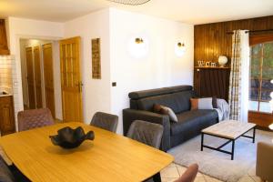 una sala de estar con una mesa y un sofá en Appartement Helios, en Les Gets