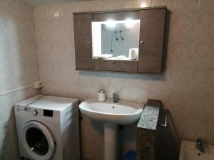 ein Badezimmer mit einem Waschbecken und einer Waschmaschine in der Unterkunft Casa sul Corso in Melito di Porto Salvo