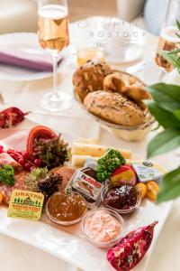 un tavolo con pane e altri prodotti alimentari e un bicchiere di vino di Stadtperle Rostock a Rostock